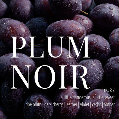 a background of wet plum fruit with white text that reads plum noir, number 82, a little dangerous, a little sweet, ripe plum, dark cherry, leather, violet, cedar, and amber
