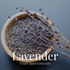 A wooden bowl of dried lavender buds with dried stems laid across it, photographed on a slate blue-grey background, with the Lavender label overlaid in white